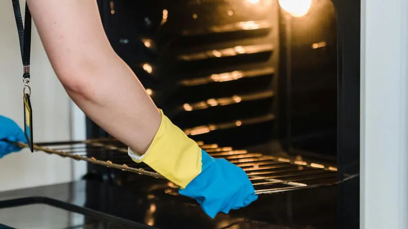 Cleaner detailing a bakery oven and control panel