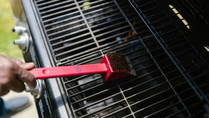 Worker scrubbing a grill grate for food truck maintenance